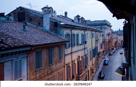 European old town street tiled roofs top Italian view picturesque dusk lights rainy pavement Piacenza Lombardy