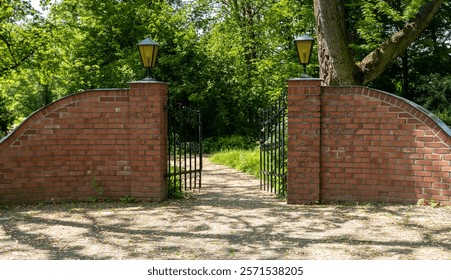 European stone fence with iron gates and lanterns in the park
