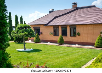 European style villa with backyard garden with nicely trimmed trees and bushes in near house. Landscape design. 