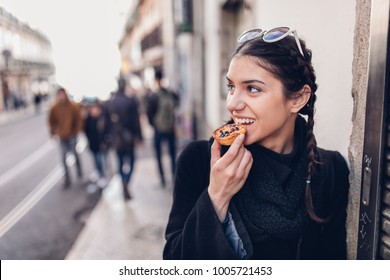 European Tourist Woman Trying Out Local Food.Eating Traditional Portuguese Egg Custard Tart Pastry Dessert Pastel De Nata.