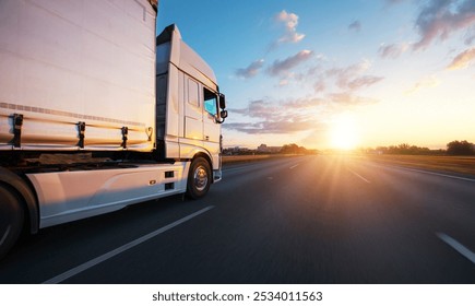 European truck driving on the asphalt road in rural landscape at sunset. Transportation and cargo concept.