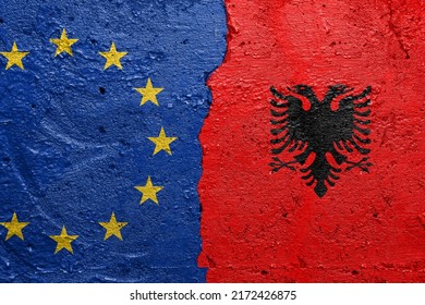 European Union and Albany flags  - Cracked concrete wall painted with a EU flag on the left and a Albanian flag on the right - Shutterstock ID 2172426875