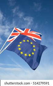 European Union And British Union Jack Flag Flying In Front Of Bright Blue Sky In Representation Of The Brexit EU Referendum