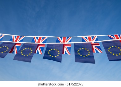 European Union And British Union Jack Flag Bunting Flying In Bright Blue Sky In A Statement Of The Brexit EU Referendum