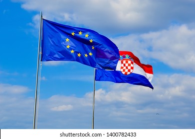 European Union and Croatian flags flutter in the breeze with blue sky background - Shutterstock ID 1400782433