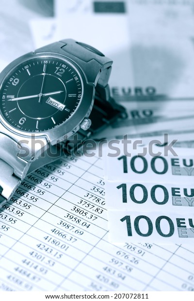 European Union Currency near wristwatch on paper\
background with digits\
table
