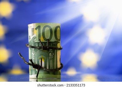 European Union currency wrapped in barbed wire against flag of EU as symbol of economic sanctions and embargo to russia as a result of russia's aggression and war in Ukraine.