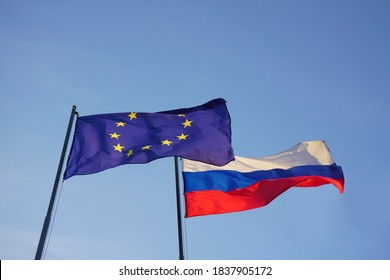 European Union -  EU -  And Russian Federation Flags On Background Of Blue Sky. Europa And Russia. 