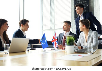 European Union and United Kingdom leaders shaking hands on a deal agreement. - Shutterstock ID 1006891726