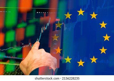  European union uptrend of the economy. Man hand shows on the increasing candle stick graph chart in the stock market with the flag on the background, March 2022, San Francisco, USA - Shutterstock ID 2136228235