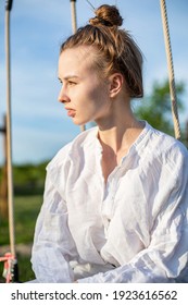 European Woman With Blonde Hair Outside Pulled Back Into A Tight Bob