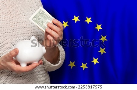 European woman with money bank on the background of EU flag. Dotations, pension fund, poverty, wealth, retirement concept