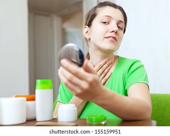 European Woman Stares On Her Neck In Mirror At Home