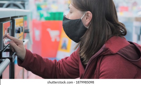 European Woman Wearing A Mask Against The Virus Chooses A New Kitchen Stove In A Home Appliance Store. The Concept Of Shopping During The Pandemic