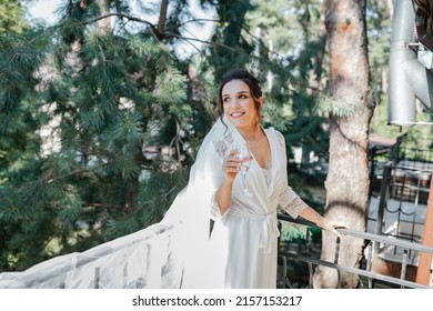 A European-looking bride in a pine forest posing with a beautiful bouquet in her hands.