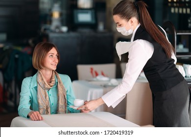 A European-looking Waiter In A Medical Mask Serves Coffee