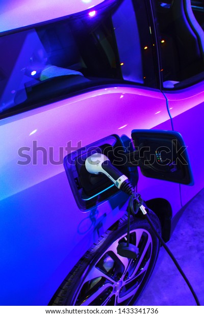 EV Car\
or Electric car at charging station with the power cable supply\
plugged. Eco-friendly alternative energy\
concept