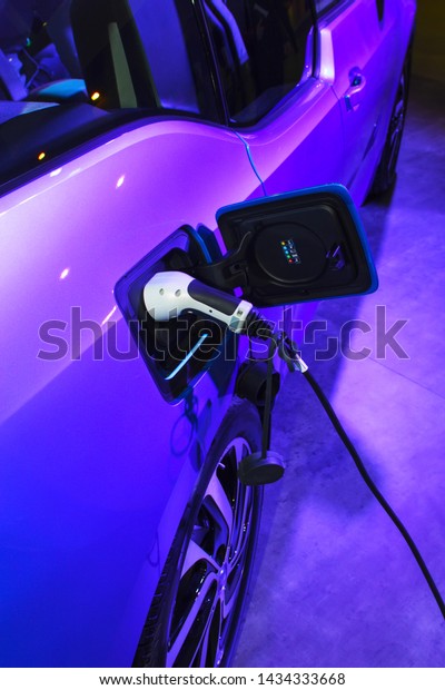 EV Car\
or Electric car at charging station with the power cable supply\
plugged. Eco-friendly alternative energy\
concept