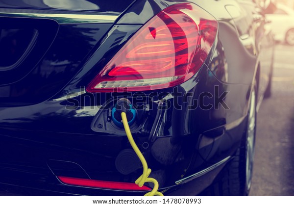 EV\
Car or Electric car at charging station with the power cable supply\
plugged in, Electric black car, Electric black vehicle, Charging\
hybrid car, Eco-friendly alternative energy\
concept.