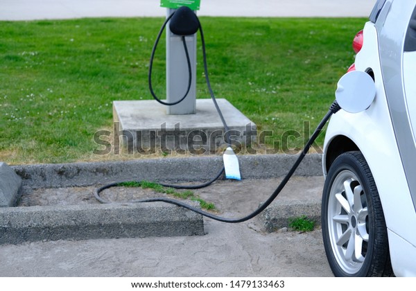 EV Car or Electric car at charging station with\
the power cable supply plugged in Eco-friendly alternative energy\
concept Vancouver