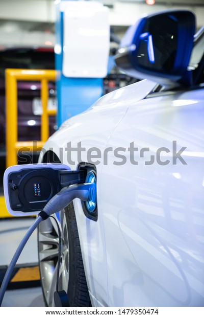 EV Car. Electric car. Charging Station with the\
power cable plugged in.Technology car. A Future transport.\
Recharging. High technology . Transportation EV. Transport EV car.\
Innovation future.