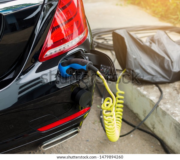 EV\
Car or Electric car at charging station with the power cable supply\
plugged in, Electric black car, Electric black vehicle, Charging\
hybrid car, Eco-friendly alternative energy\
concept.