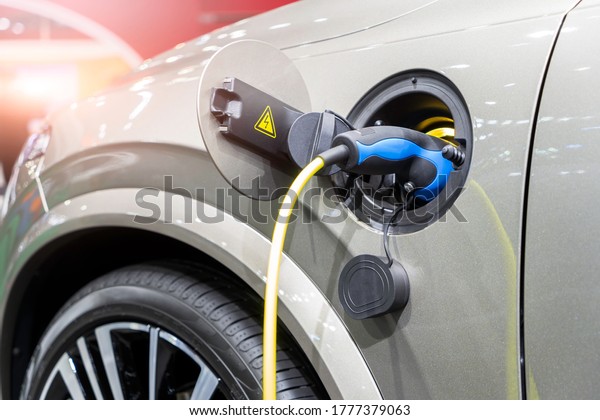EV Car or Electric car at charging\
station with the power cable supply plugged, Charging vehicle\
technology industry transport, EV fuel Plug in hybrid\
car.\
