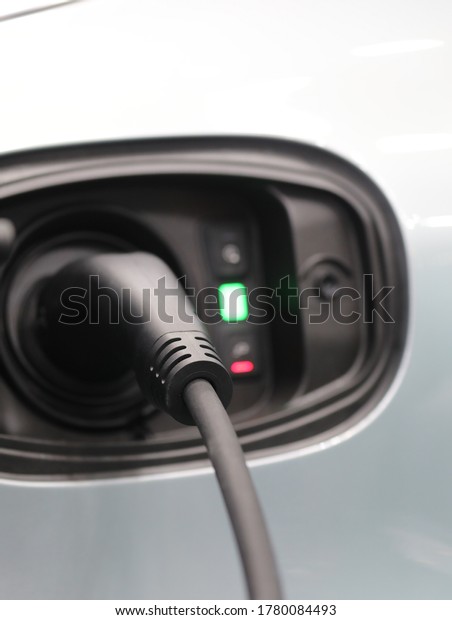 EV Car or\
Electric car at charging station with the power cable\
supply.Eco-friendly alternative energy\
concept