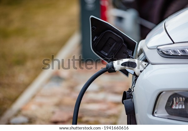 EV Car or Electric car at charging station\
with the power cable supply plugged\
in