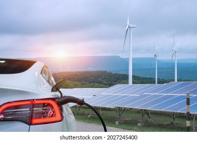 EV Car or electric power car and solar cells for electricity generation,plug of power cable electric supply during charging at ev car. - Shutterstock ID 2027245400