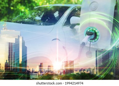 EV Car or Electric vehicle concept with double exposure on cityscape background, Power cable supply plugged in on blurred nature with green energy power effect. Eco-friendly sustainable energy. - Shutterstock ID 1994214974