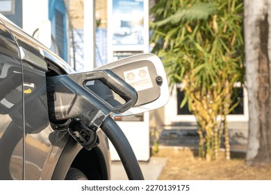 An EV car is plugging with the DC CSS type 2 charger head for refueling the energy. New technology for transportation. Close-up and selective focus.