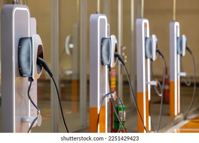 EV charging an electric car. Power supply for electric car charging. Socket for electrical car battery charger. EV car charging station in parking. Nature energy, Clean energy, Green eco concept. - Shutterstock ID 2251429423