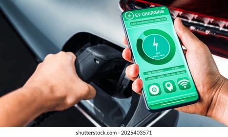 EV charging station for electric car with mobile app display charger status . The electric power is produced from sustainable resources to supply to charger station in order to reduce CO2 emission . - Powered by Shutterstock