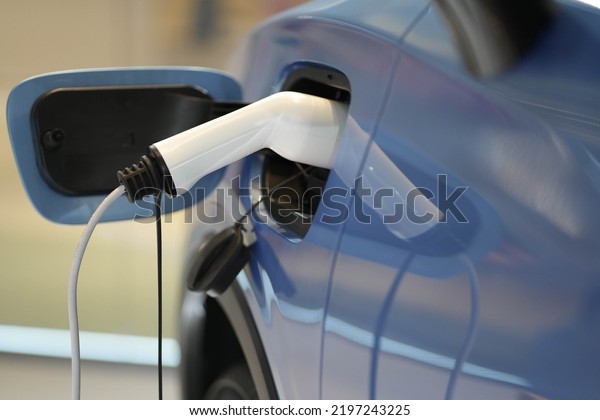 EV charging station for electric car of green energy\
and eco power produced from sustainable source to supply to charger\
station. EV Car vehicle at charging station. power cable supply\
plugged in