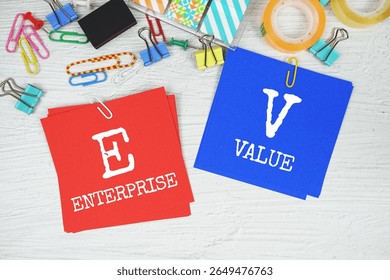 EV - Enterprise Value text on stick note with stationery on concrete background