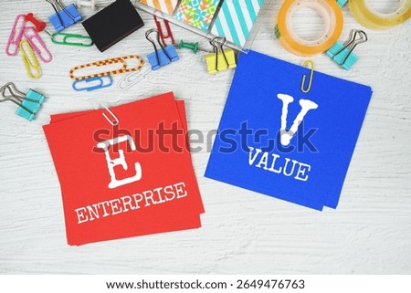 EV - Enterprise Value text on stick note with stationery on concrete background