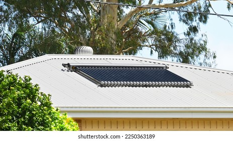 Evacuated tube solar hot water heater tubes on a metal roof - Shutterstock ID 2250363189