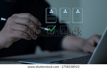 Evaluation and approval process. A professional checks candidate profiles and approves the selection with a green check mark on a digital laptop interface.