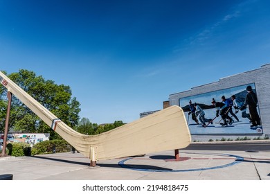 Eveleth, Minnesota -2022: World's Largest Free-Standing Hockey Stick  In Ice Hockey Plaza In Town Nicknamed Hockeytown USA. Big Stick Or The Stick. Mural Of Pond Hockey Or Shinny.