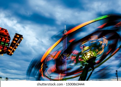 Evening Amusement Par Ride With Dark Dramatic Sky