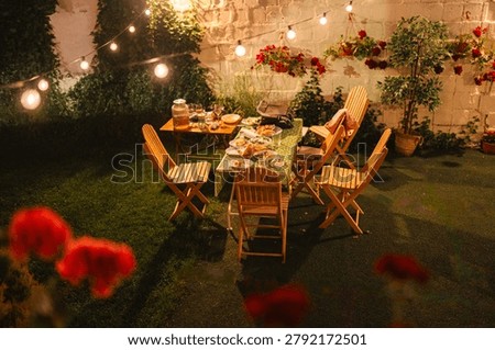 Evening backyard party with a long table of food and glowing string lights