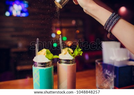 Evening at the bar. The barman pours alcohol into a glass. Club hand