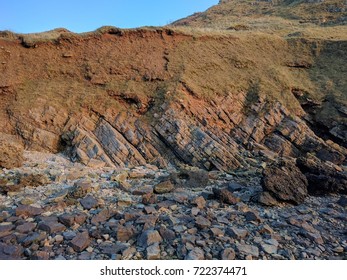 Evening At The Beach By The Cliffs Scene Showing Sand Rocks Subduction Zone Textures Grass And Sky