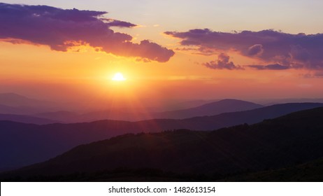 Evening in Carpathians Mountains. The sun falls for gorizon, a sunset. Shadows are condensed, beautiful clouds. Bright orange and violet colors. Tranquility of summer evening - Shutterstock ID 1482613154