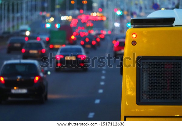 Evening, city traffic jams, city street road.\
Yellow bus close-up