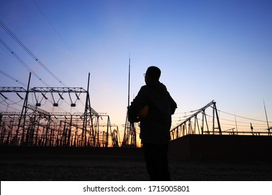 In the evening, electricity workers and pylon silhouette, Power workers at work