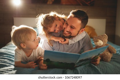 evening family reading. father reads children a book before going to bed 