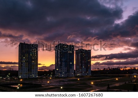 evening fluffy curly rolling clouds of awesome sunset before storm against the background of multi-storey apartment buildings