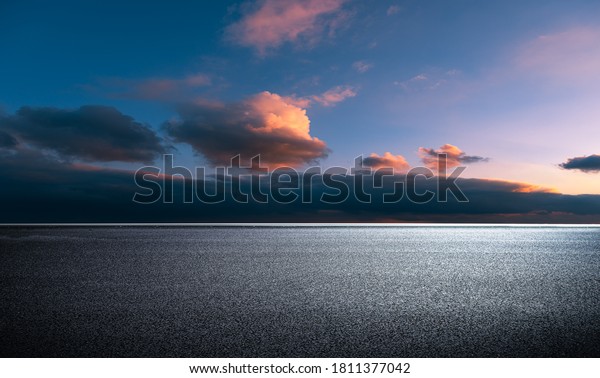  In the evening glow, the wide asphalt\
pavement overlooks the city buildings \

